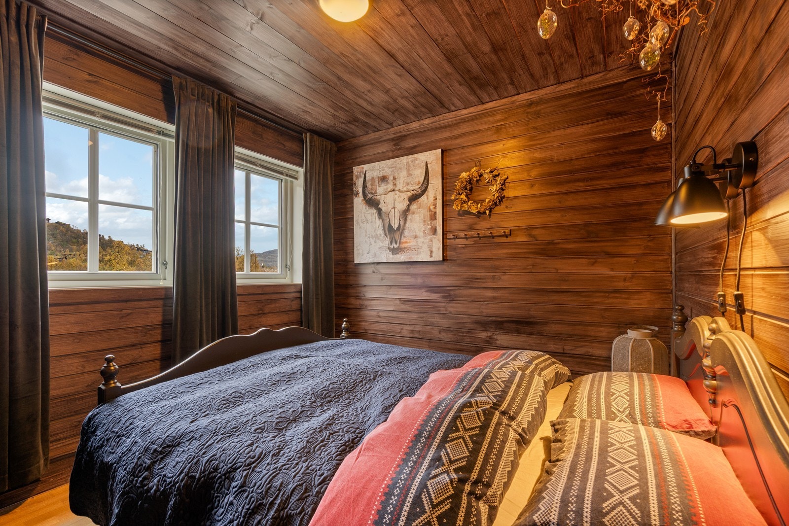 Soverom 2, innredet med dobbeltseng og vegger beiset i en lun farge som skaper en koselig atmosfære. Galleribilde