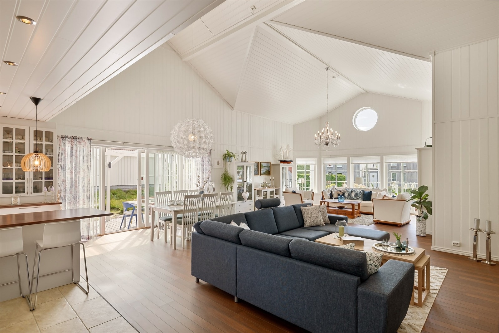 Gjennom hvitmalt panel, skipsgulv-inspirert laminat og koøye i gavlveggen har stuen tydelige maritime referanser. Galleribilde