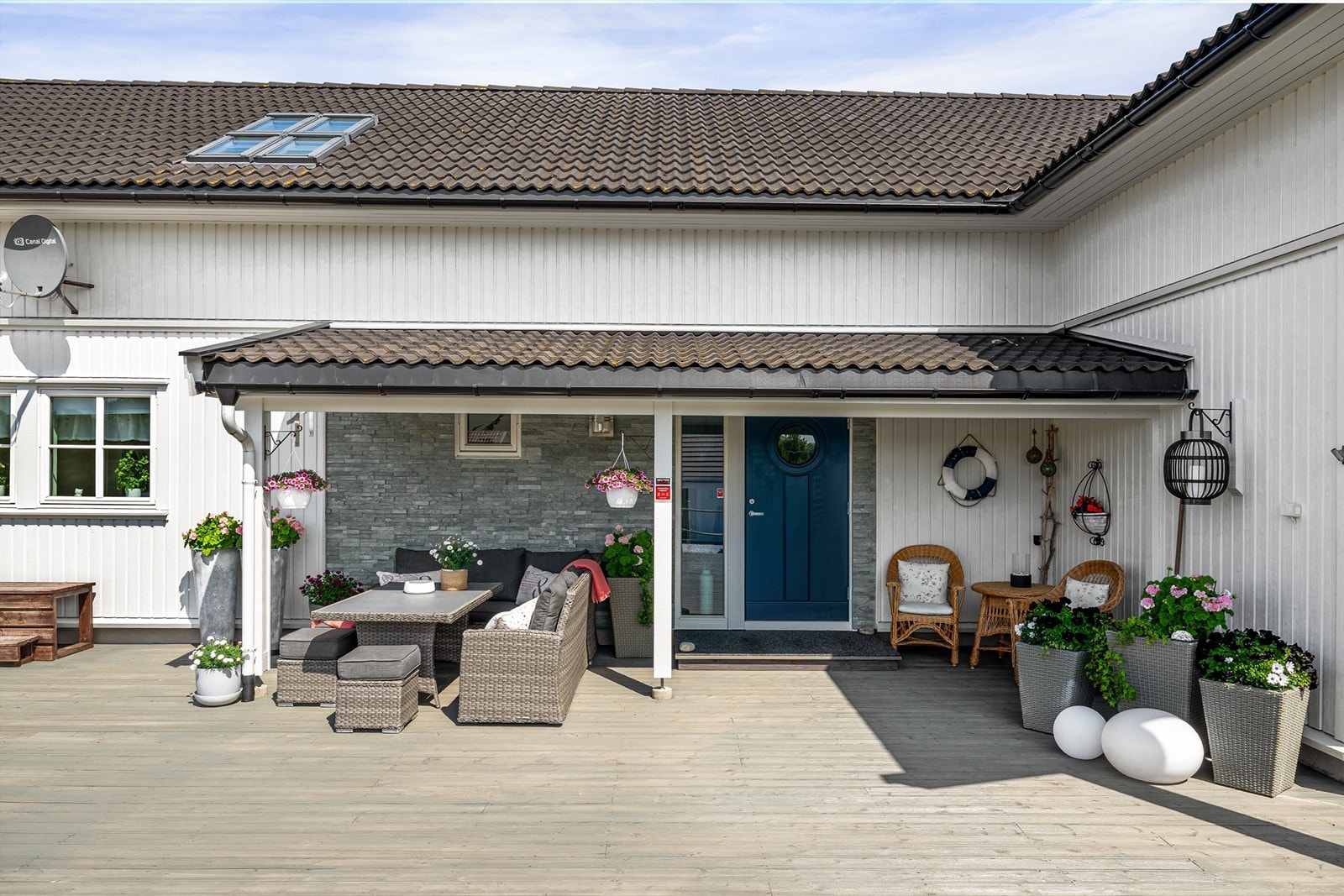 Inngangspartiets overbygg skjermer mot nedbør og gir sval skygge på varme sommerdager. Galleribilde