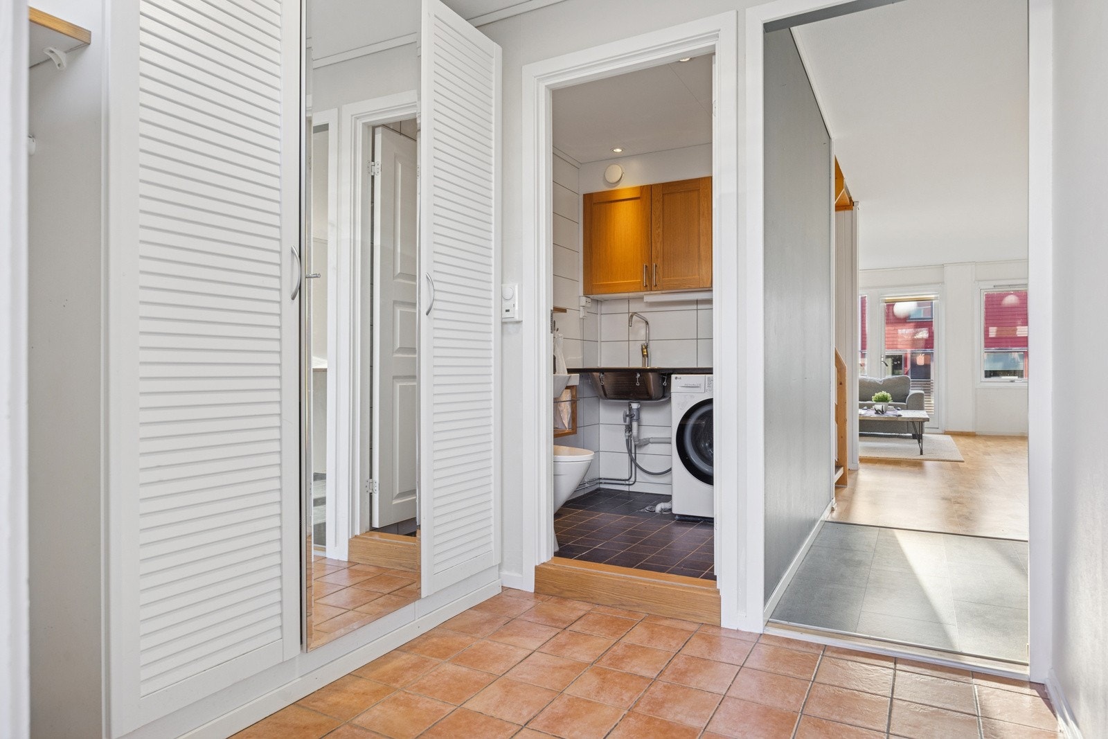 Vegg i vegg med entréen er et flislagt vaskerom. Galleribilde