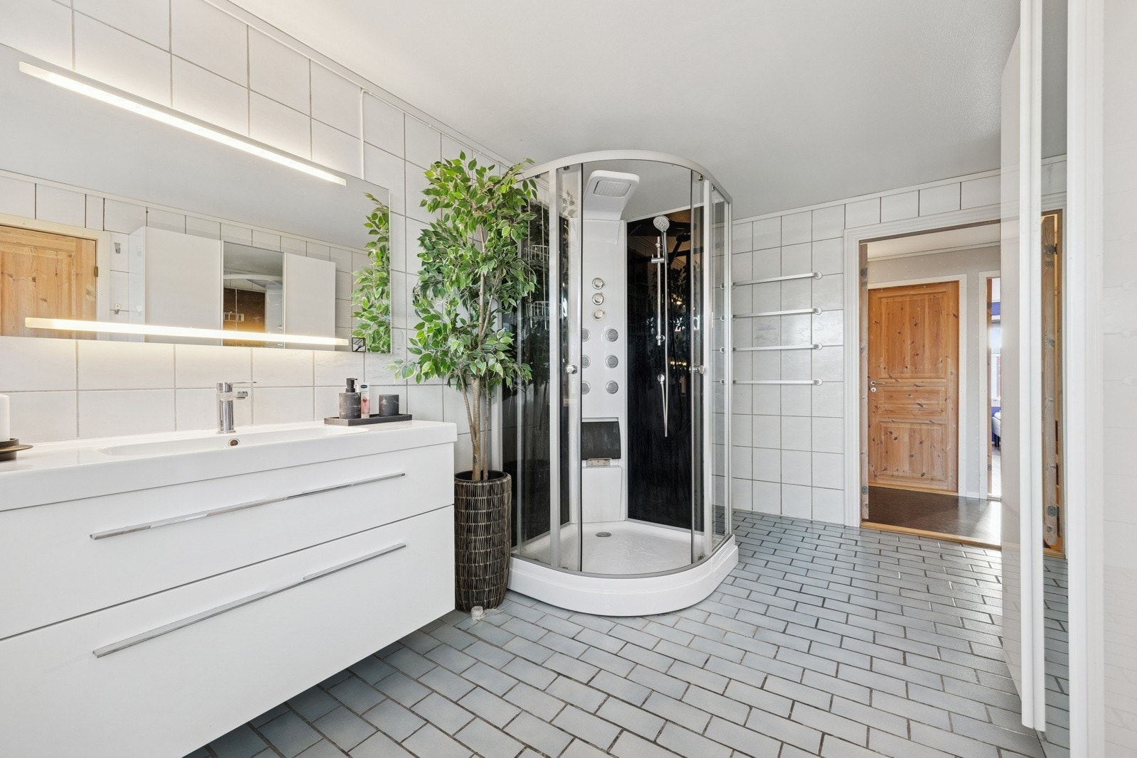 Det ca. 10 kvm store badet har flislagte overflater og svært god lagringsplass. Galleribilde