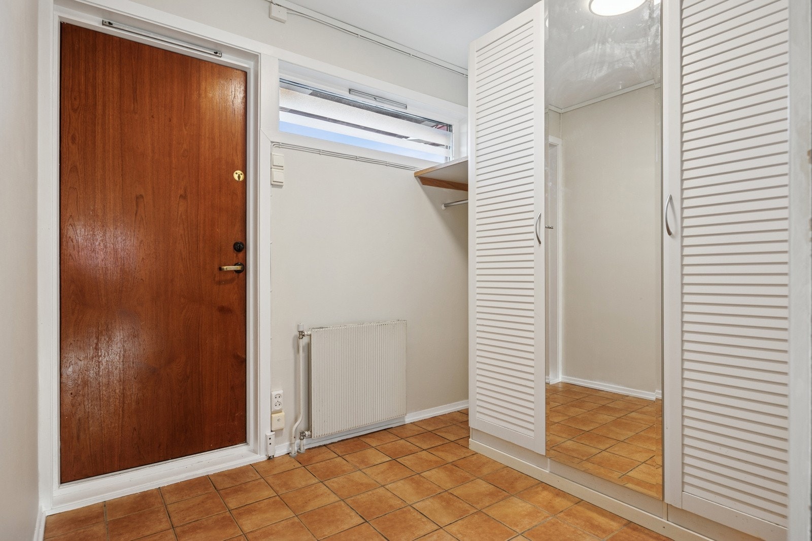 Innenfor døra blir man møtt av en flislagt entré med god plass til oppbevaring av klær og sko. Galleribilde