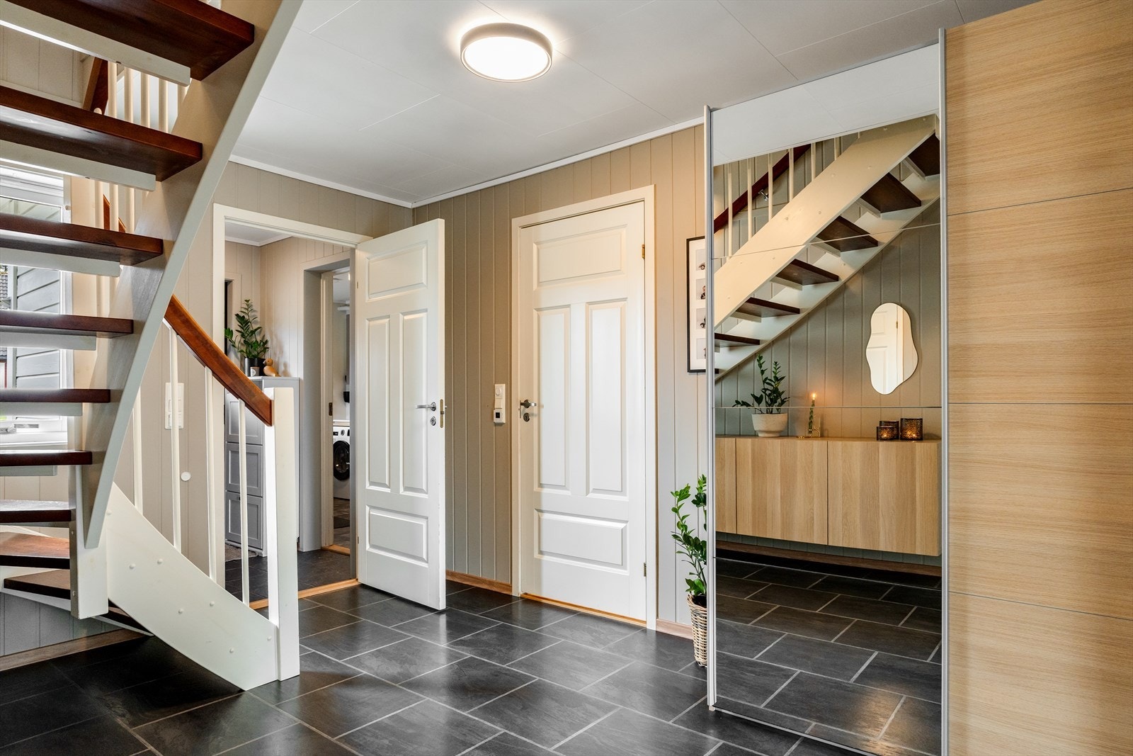 Romslig hall med skyvedørsgarderobe og trapp opp til andre etasje. Galleribilde