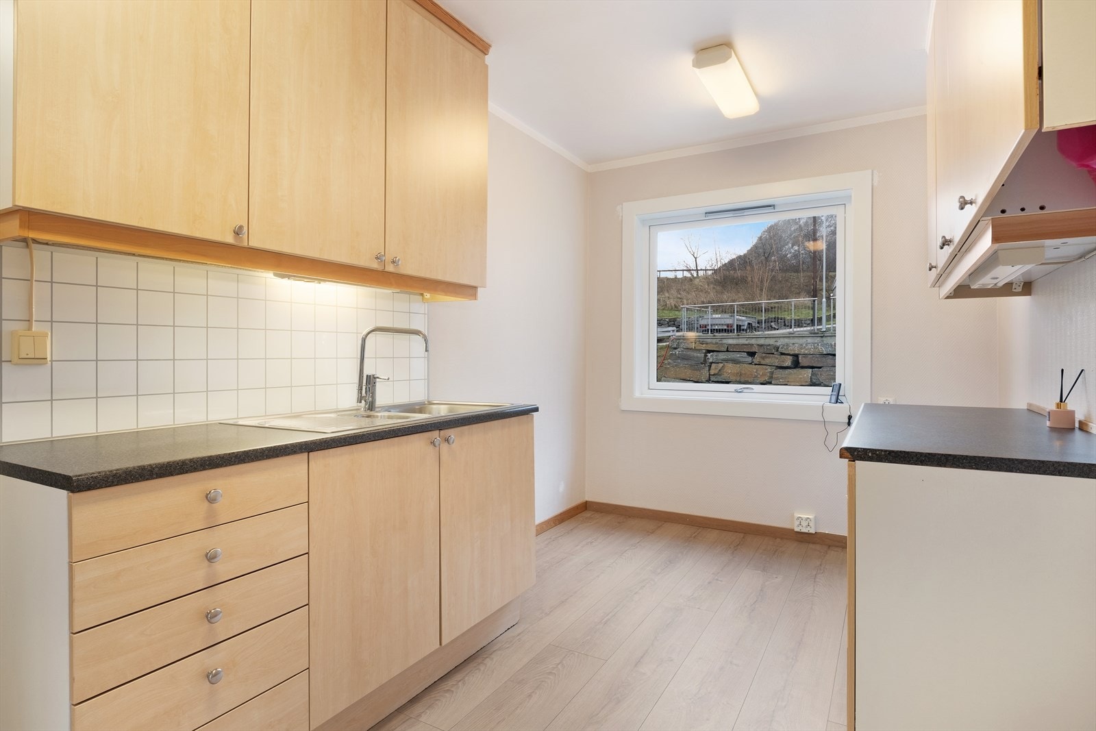 Kjøkenet har lyse overflater og plass til innreiing av eit mindre kjøkenbord. Galleribilde