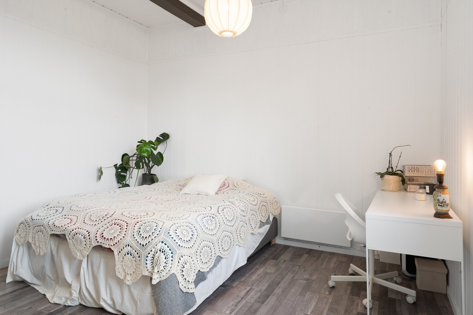 Rommet har vegger med malt panel og laminat på gulvet, som gir et lyst og helhetlig inntrykk. Galleribilde