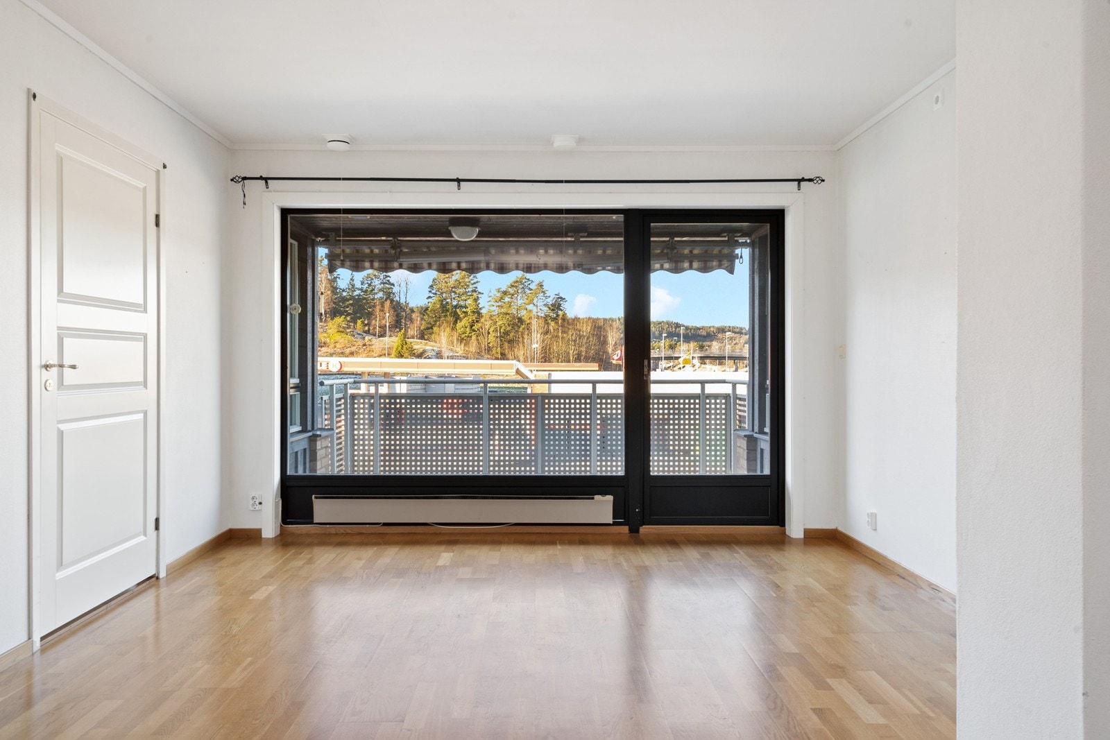 Store vindusflater gir godt utsyn fra stuen, mens parkettgulvet gir en solid overflate. Galleribilde