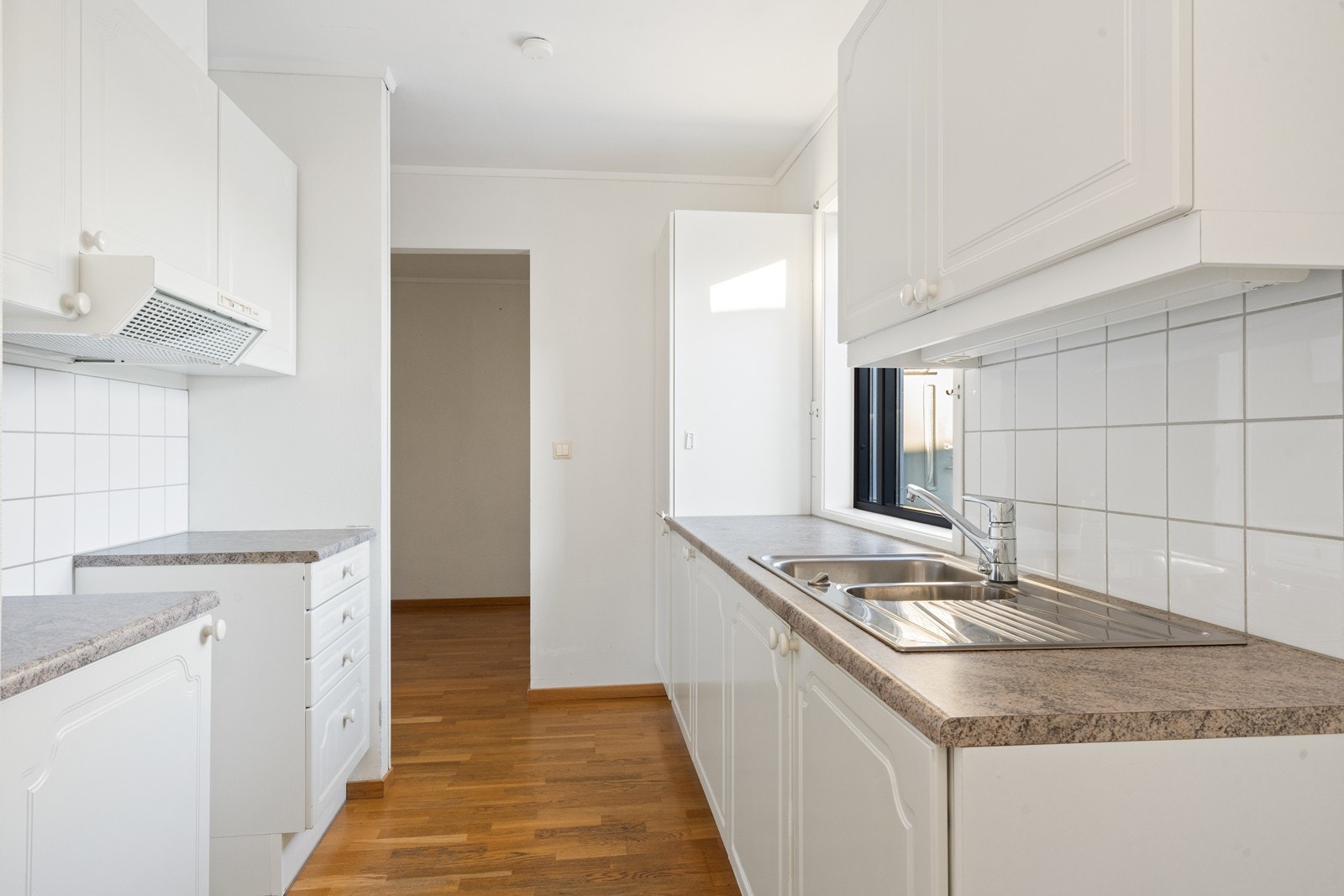 Kjøkkenet har profilerte fronter og en benkeplate av laminat, med ventilator og avtrekk ut fra kjøkkenet. Galleribilde