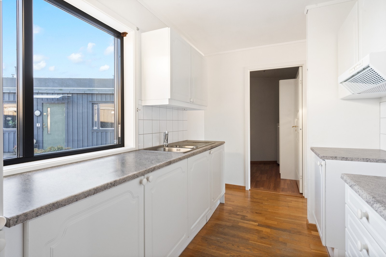 Store vinduer gir godt med dagslys, og kjøkkenet har en praktisk benkeplass. Galleribilde