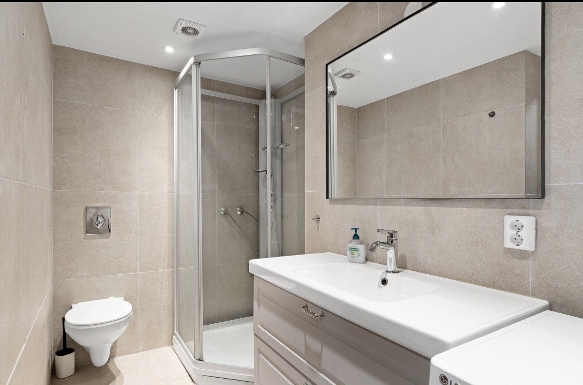 flislagt bad med servant toalett og dusjnisje Galleribilde