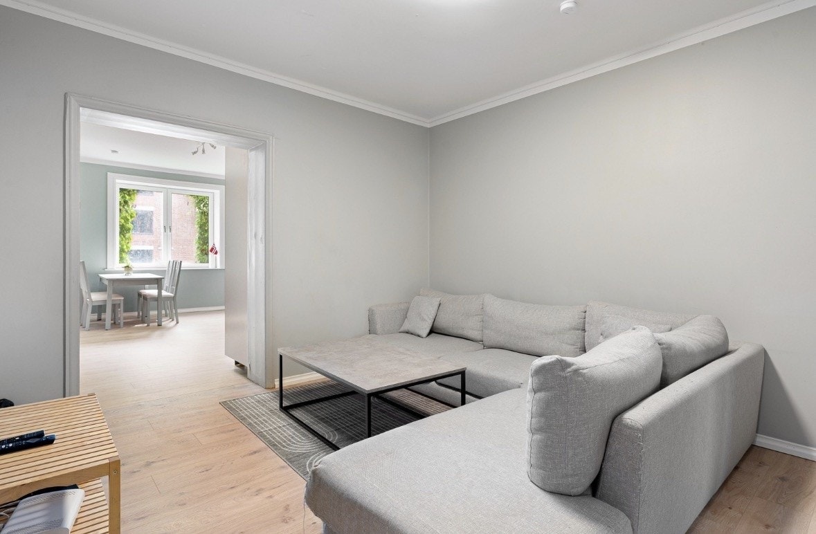 Stue med stor sofa, og en stor 85 tommer tv Galleribilde