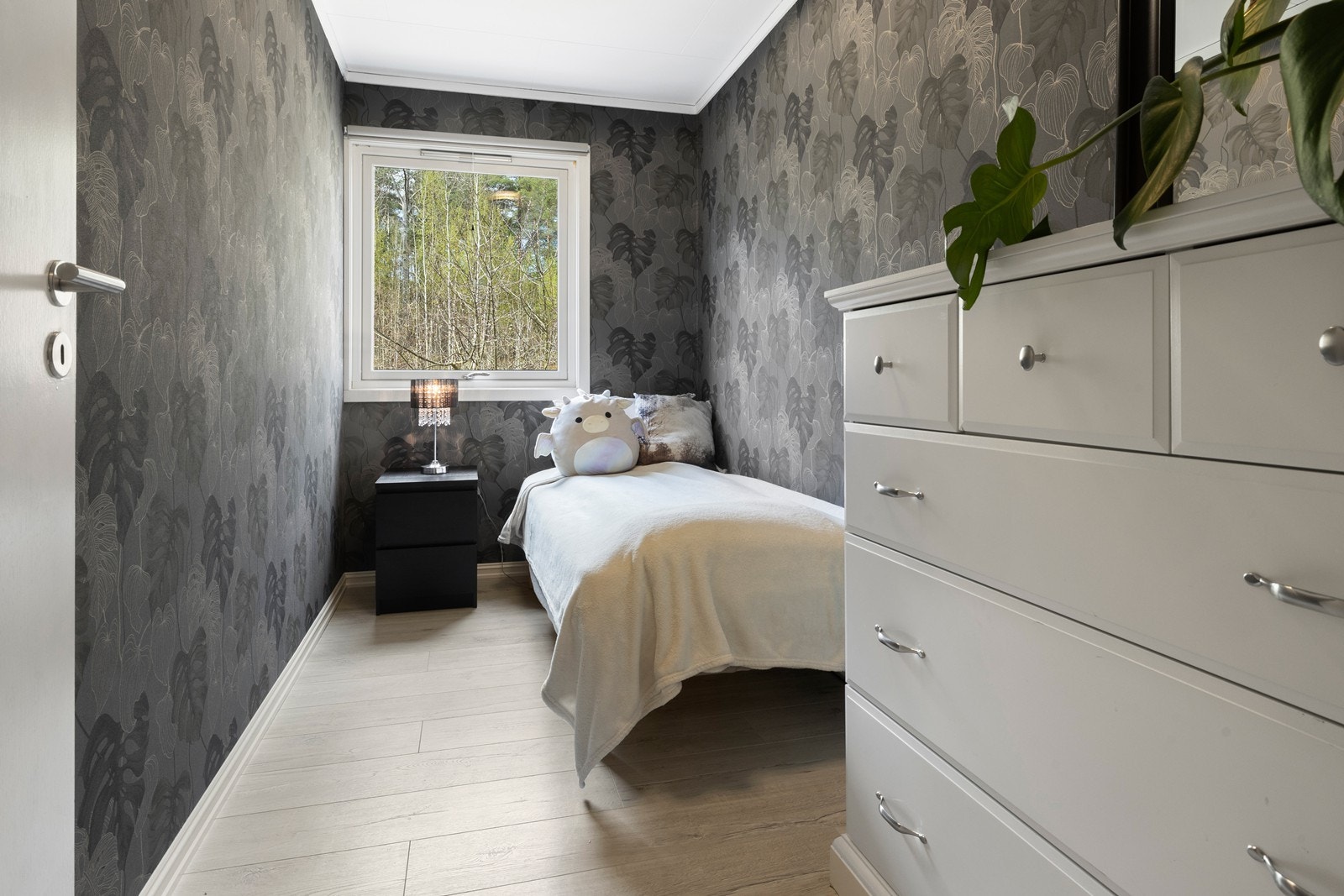 Det miste soverommet er pent oppusset med tapet og laminat på gulvet Galleribilde