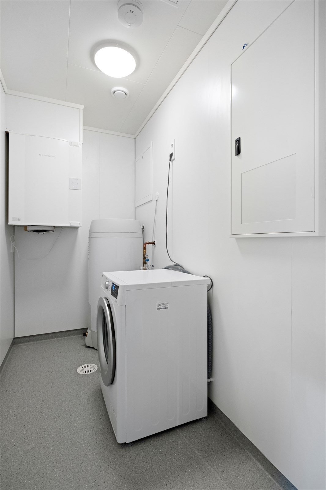 Vaskerommet har vinylbelegg på gulv og baderomsplater på veggene, med opplegg for vaskemaskin. Balansert ventilasjonsanlegg gir effektiv avtrekk i rommet. Galleribilde