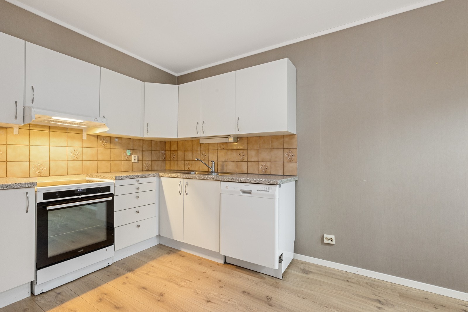 Kjøkkenvasken av rustfritt stål er nedsenket i benkeplaten og har vaske- og skyllekum. Galleribilde