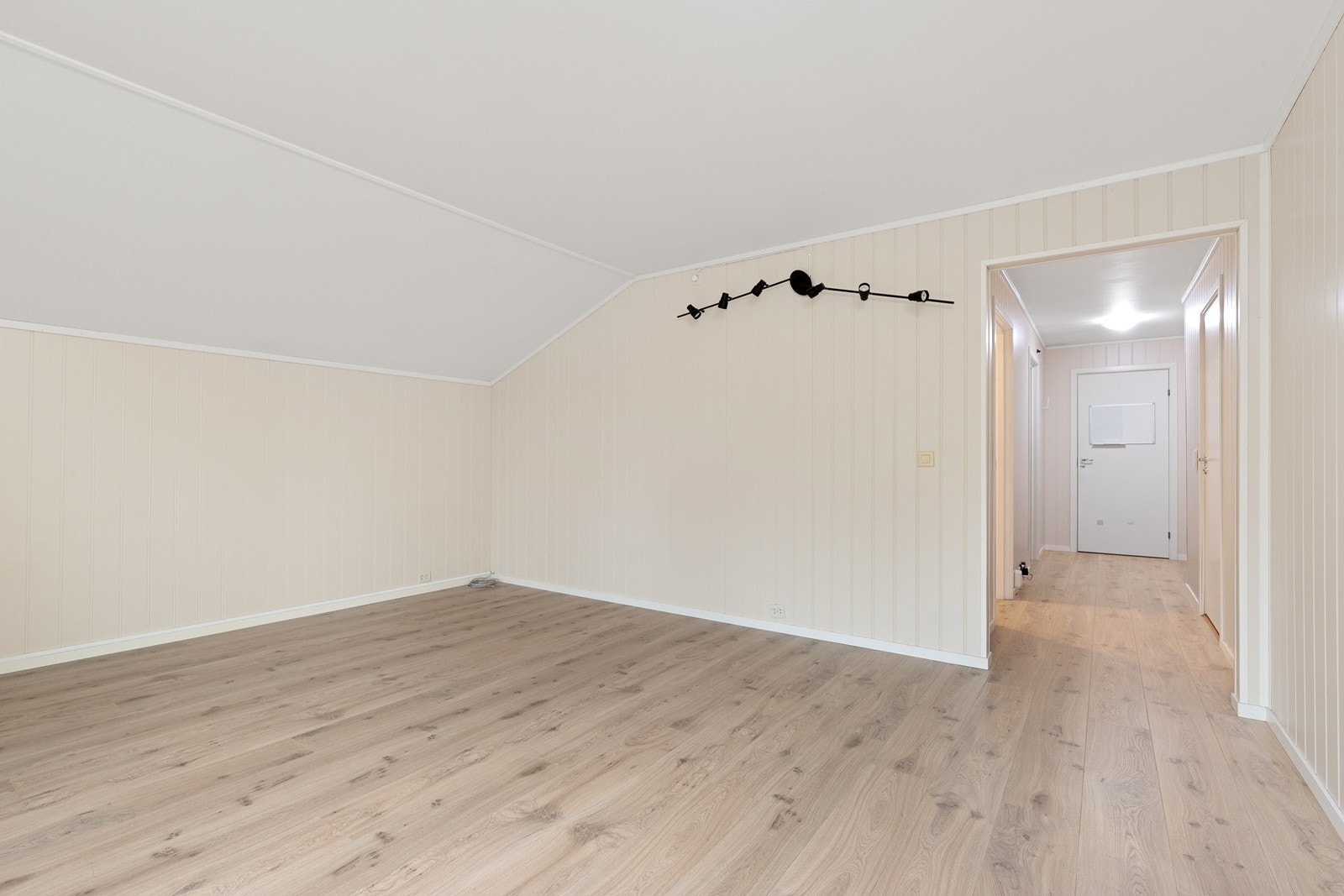 Store gulvflater i laminat gir rom for fleksibel møblering i oppholdsrommet. Galleribilde