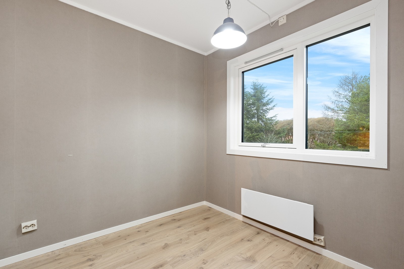 Rommet har laminatgulv og naturlig lysinnslipp fra vinduene. Galleribilde