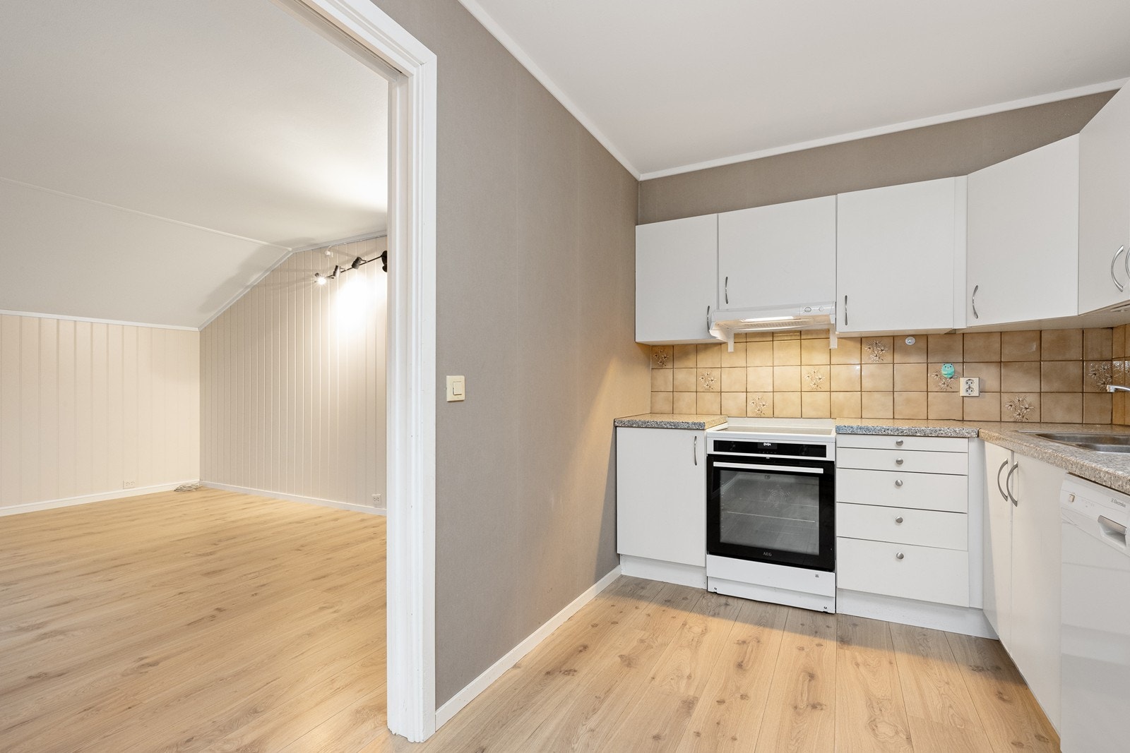 Kjøkkenet har slette fronter og laminerte benkeplater med opplegg for oppvaskmaskin. Galleribilde