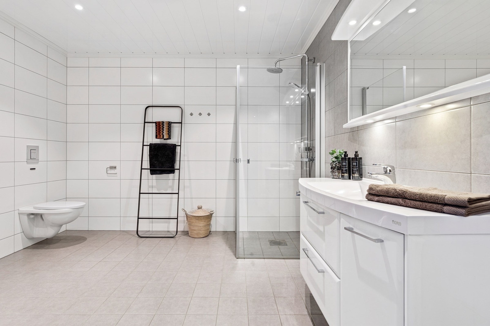 Badet i første etasje er helfliset og utstyrt med både dusjhjørne og badekar. Galleribilde