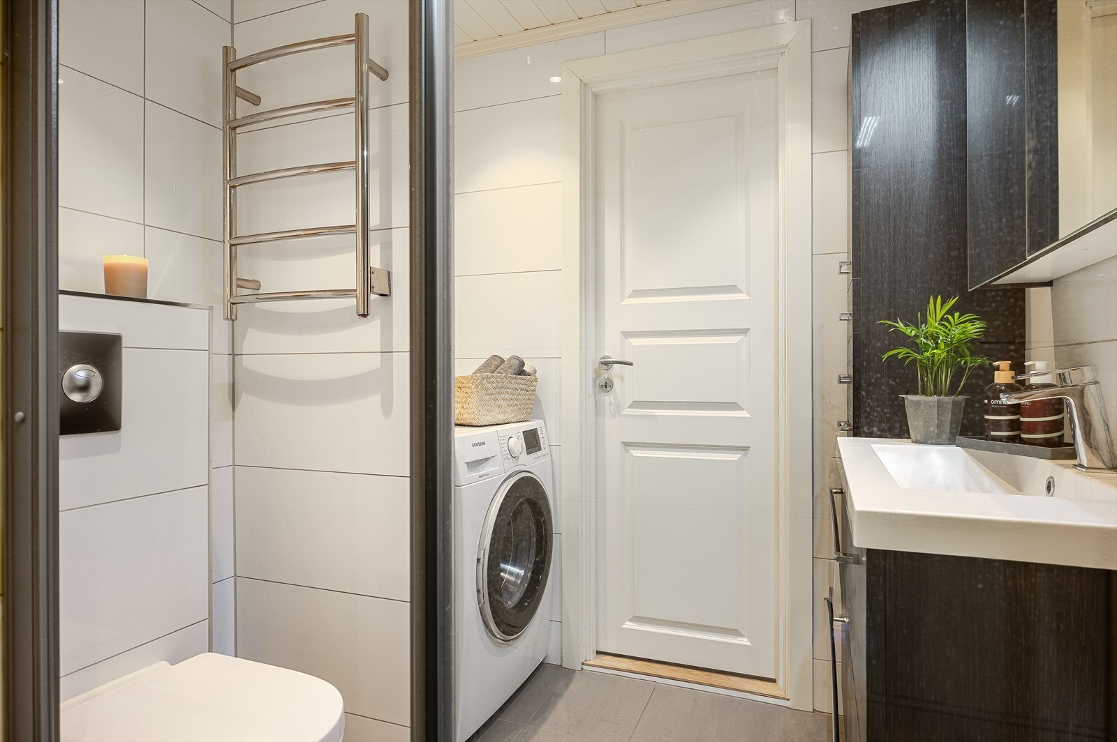 Badet er utstyrt med veggmontert toalett og har nisje med plass og opplegg for vaskemaskin. Galleribilde