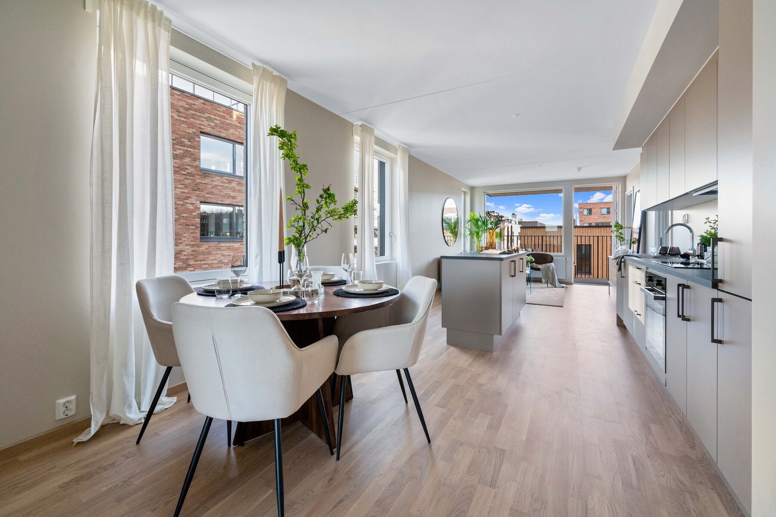 Lys og lun spiseplass med store vinduer og god plass til et større spisebord Galleribilde