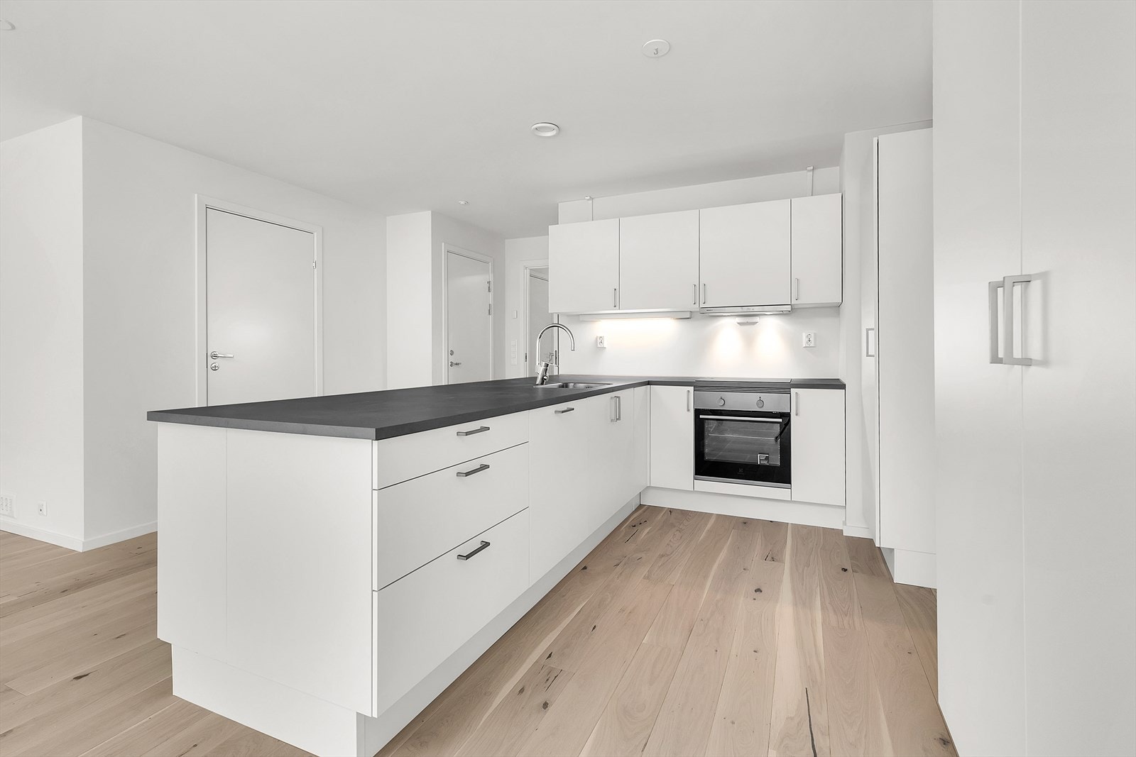 Kjøkkenet har integrerte hvitevarer som oppvaskmaskin, platetopp og stekeovn Galleribilde