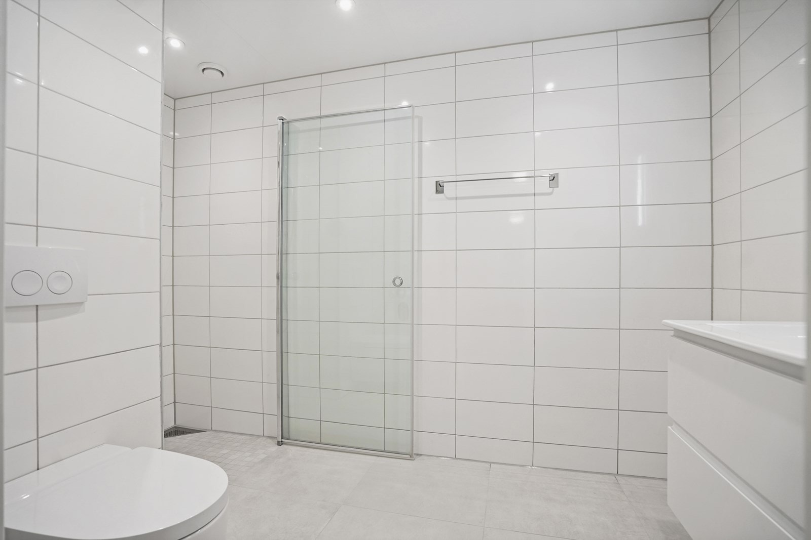 Stilrent baderom med fliser på vegg og gulv. Fliser på gulv fra april 2025. Galleribilde