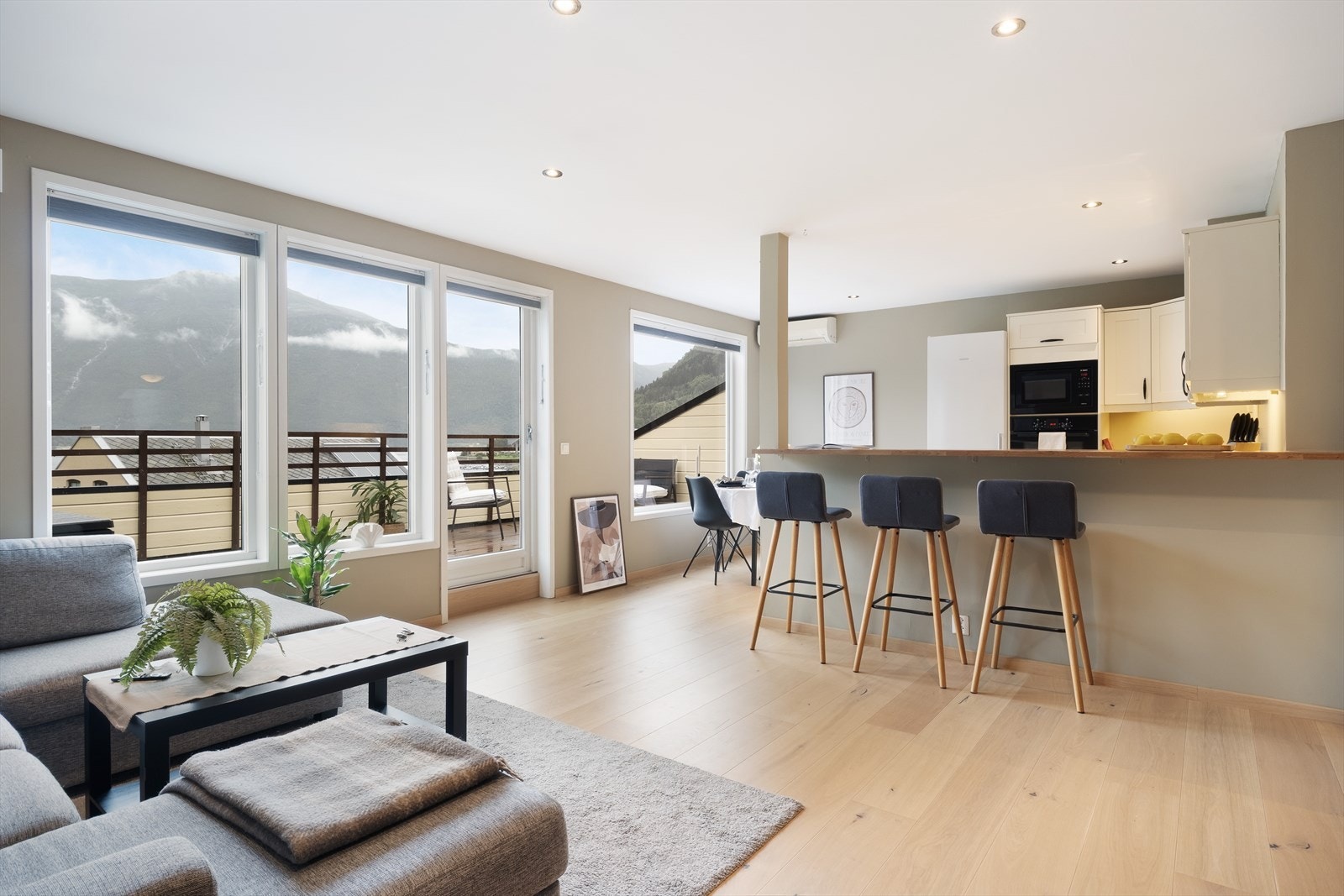 Leilegheita har eit lyst og luftig opphaldsrom med store vindauger i front og uhindra utsikt over fjorden og fjella rundt. Galleribilde