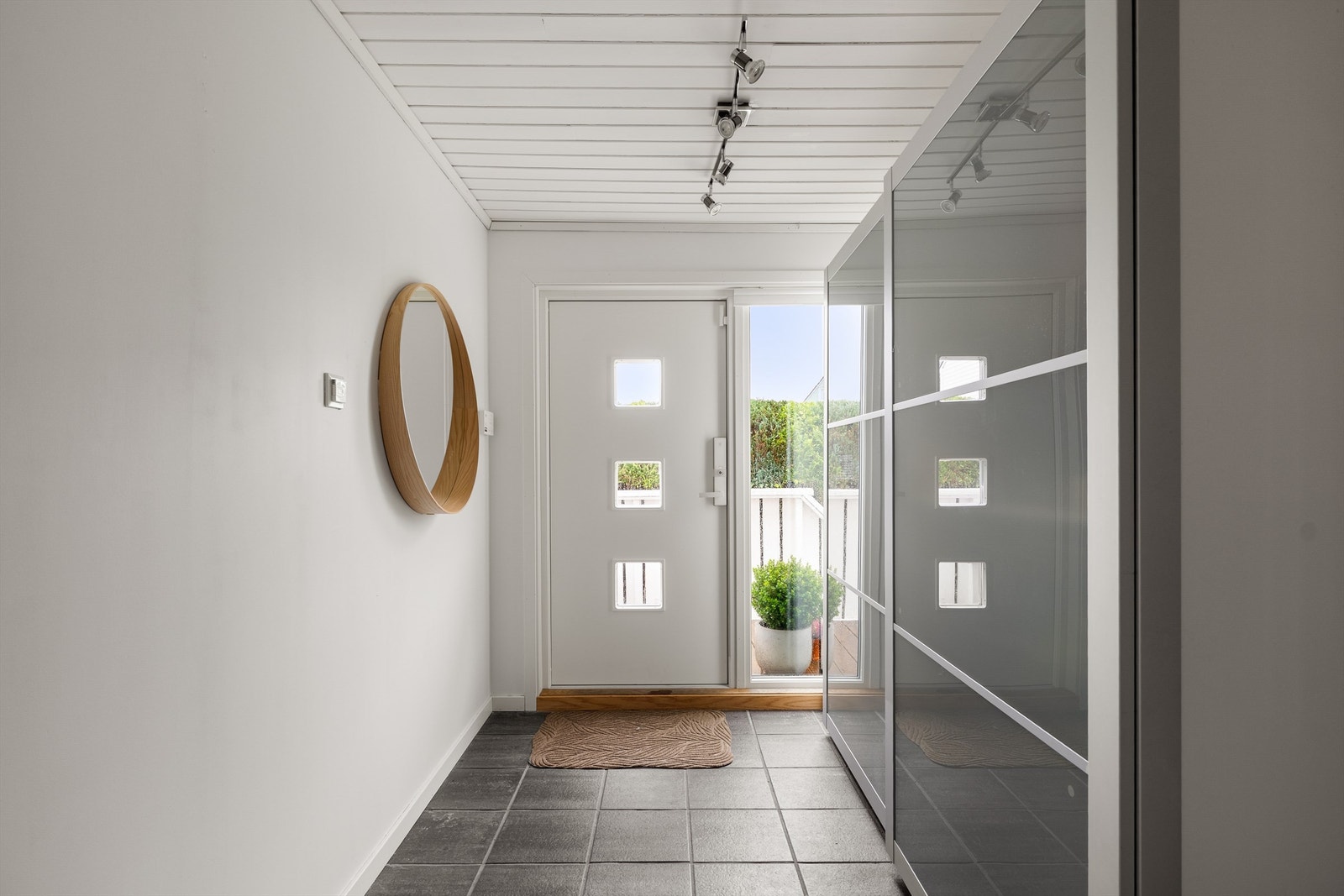 Entréen er fliselagt og praktisk innredet med skyvedørsgarderobe. Galleribilde