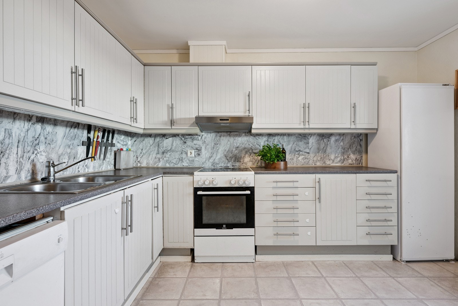 Kjøkkenet har slett innredning, laminat benkeplate og nisjer for hvitevarer. Galleribilde