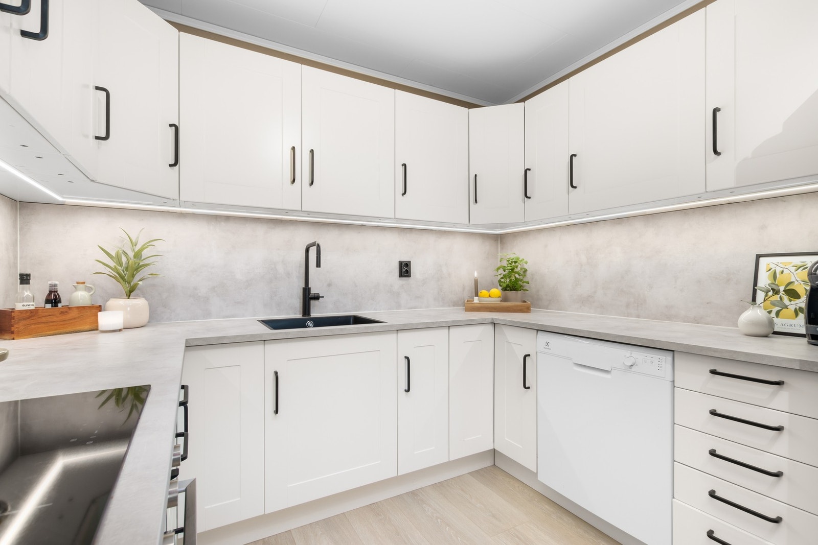 Kjøkken med benkeplate, platetopp, stekeovn, vaskekumme og kjøkkenbatteri i 2023. Galleribilde