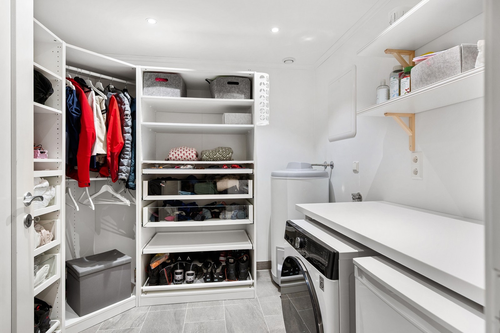 Praktisk vaskerom med opplegg til vaskemaskin og god lagringsplass. Galleribilde