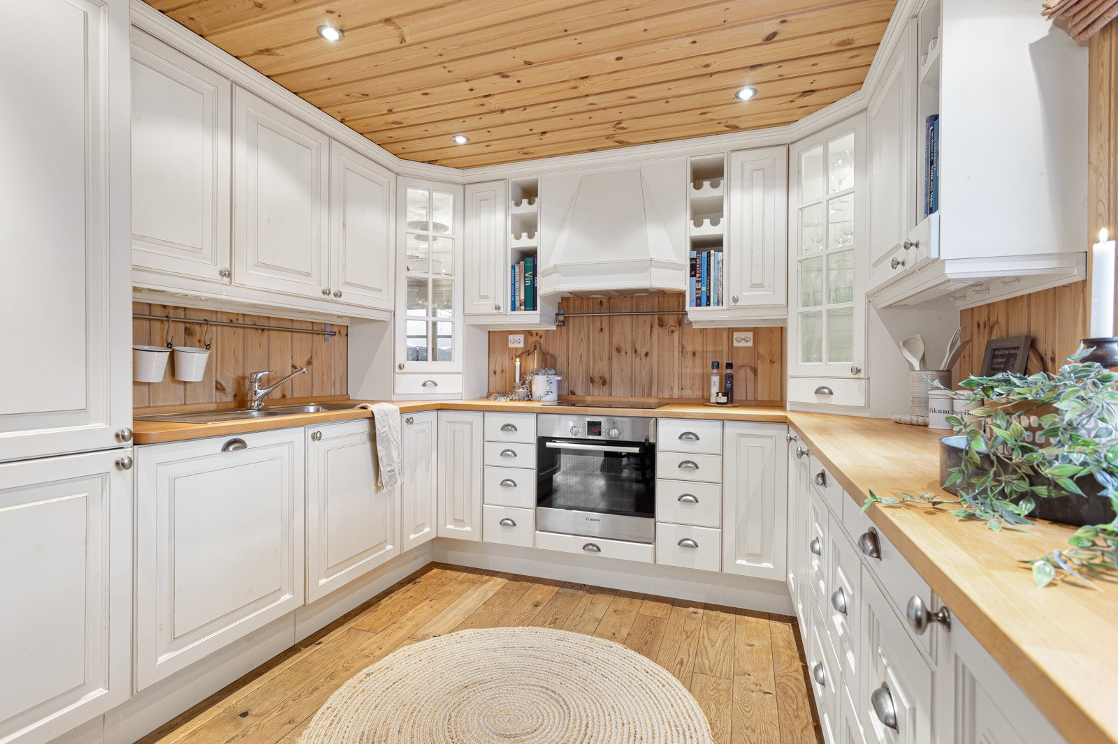 Kjøkkenet inneholder hvitevarer som komfyr, platetopp, kjøleskap med frysedel og oppvaskmaskin Galleribilde