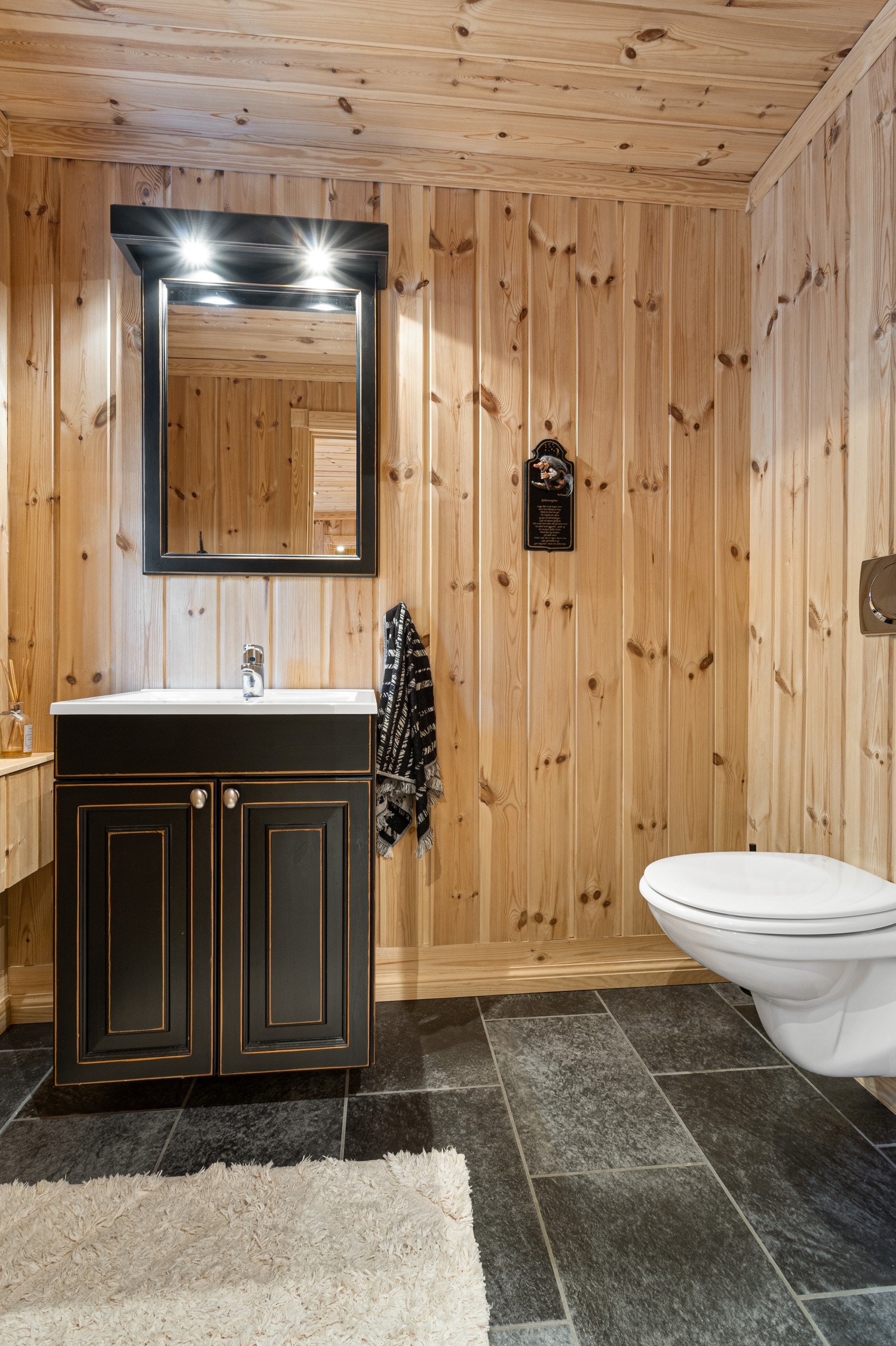 Praktisk toalettrom innredet med toalett, servant med innredning og speil. Rommet har direkte inngang fra entreen slik at man kan beholde skiskoene på Galleribilde