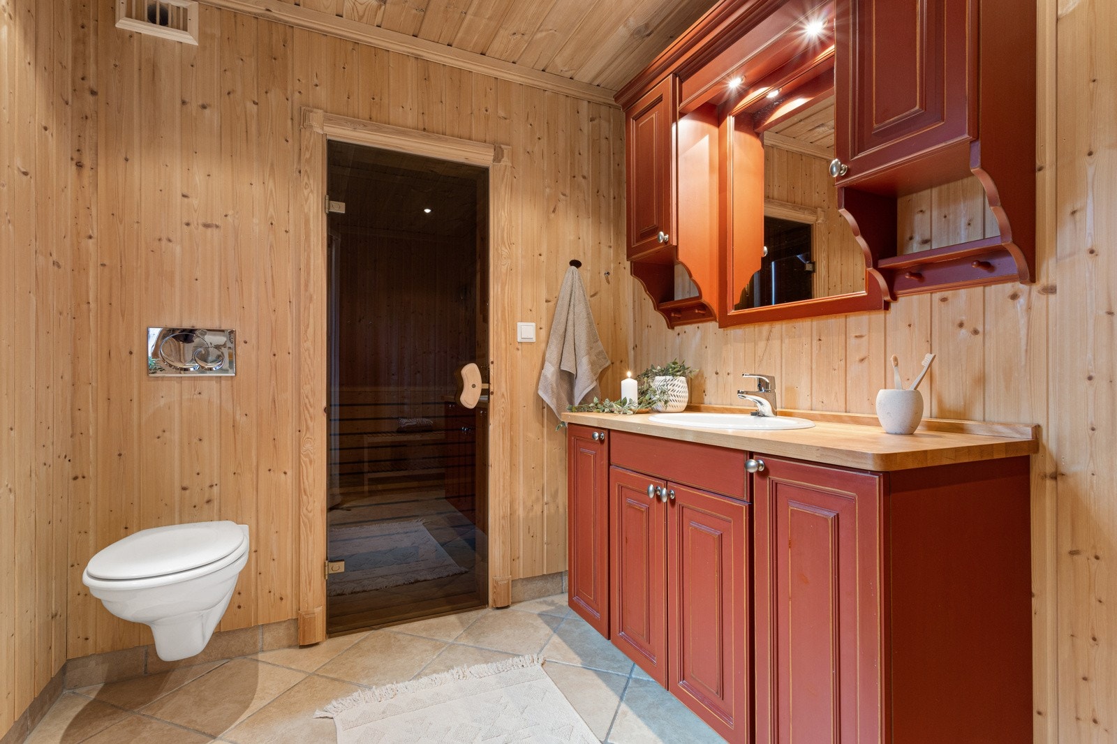 Badet har flislagt gulv med varmekabler og panel på vegger Galleribilde