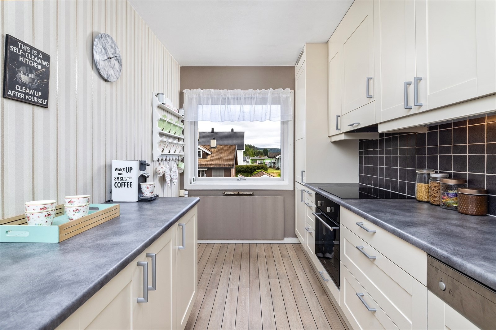 Integrerte hvitevarer og plass for lite kjøkkenbord ved vindu Galleribilde