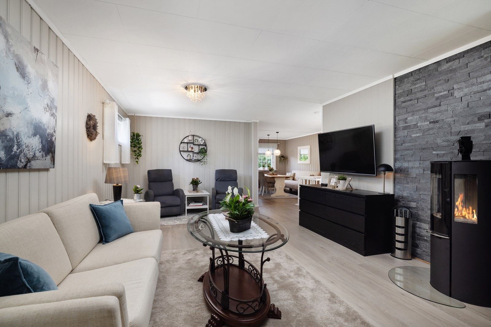 Den ene stuen har en peisovn fra 2021 som gir effektiv varme og en hyggelig atmosfære. Galleribilde