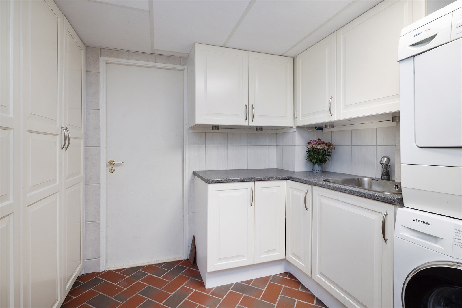 Praktisk vaskerom i underetasjen med innredning og opplegg for vaskemaskin. Galleribilde