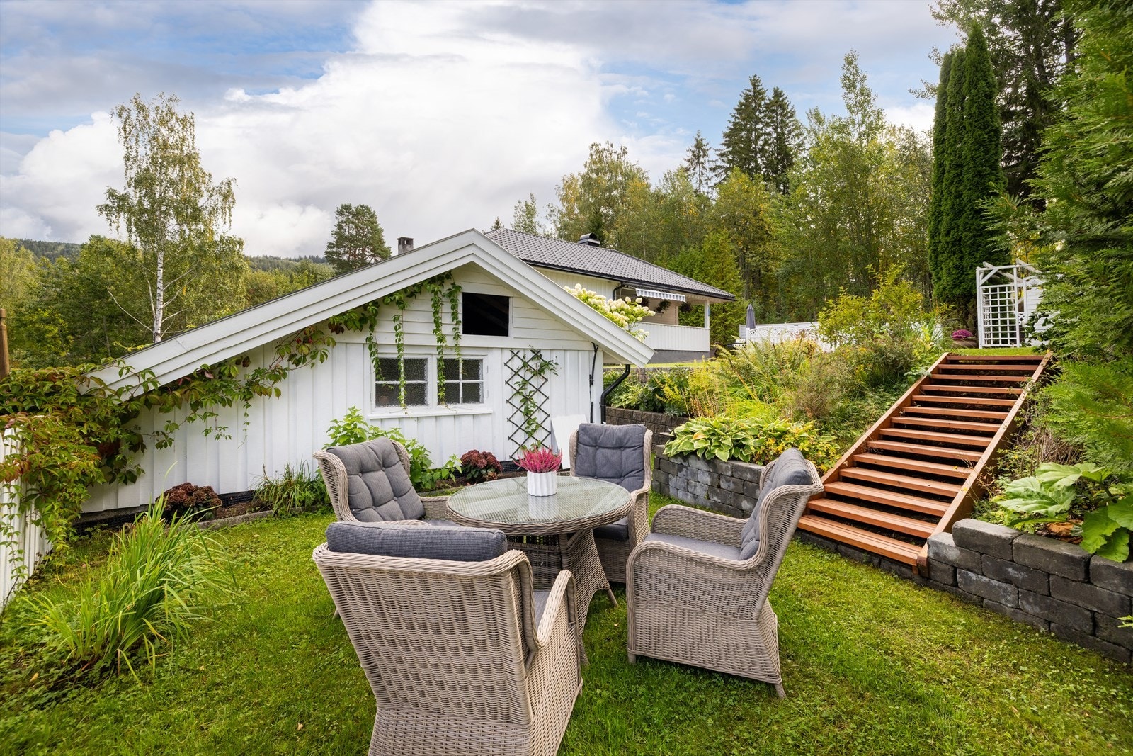 Tomten er pent opparbeidet med plen, beplantning og flere hyggelige uteplasser. Galleribilde