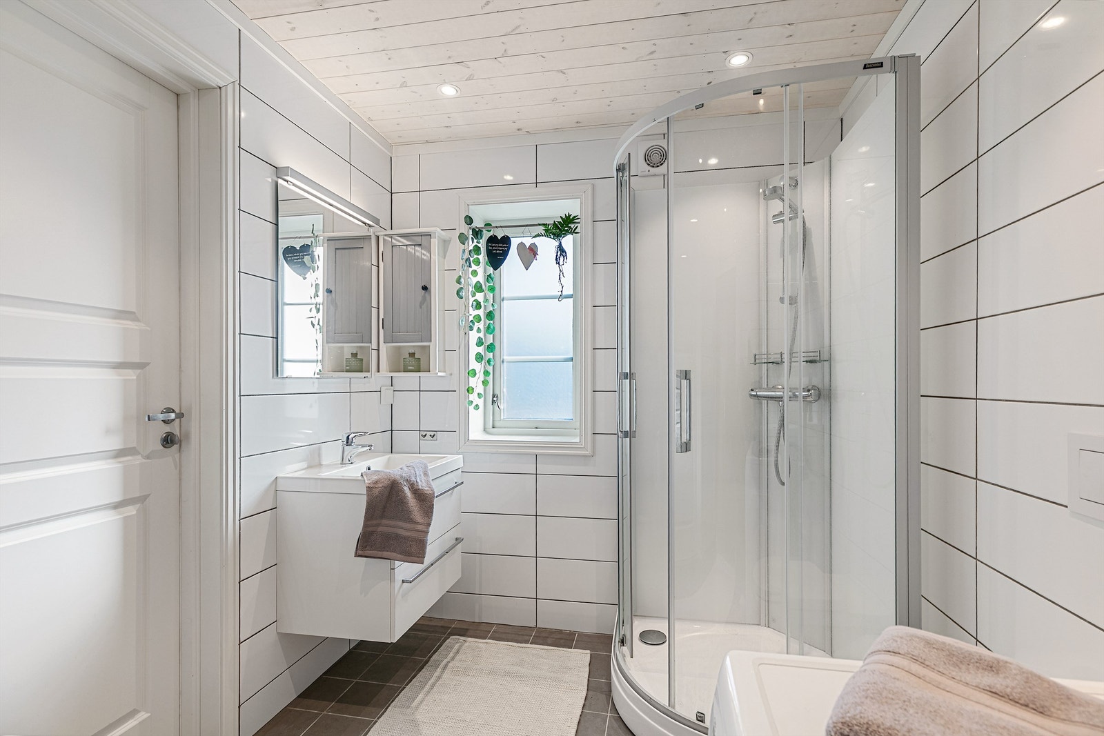 Badet er delikat med flislagt gulv med varmekabler, og stemningsfull downlightsbelysning Galleribilde