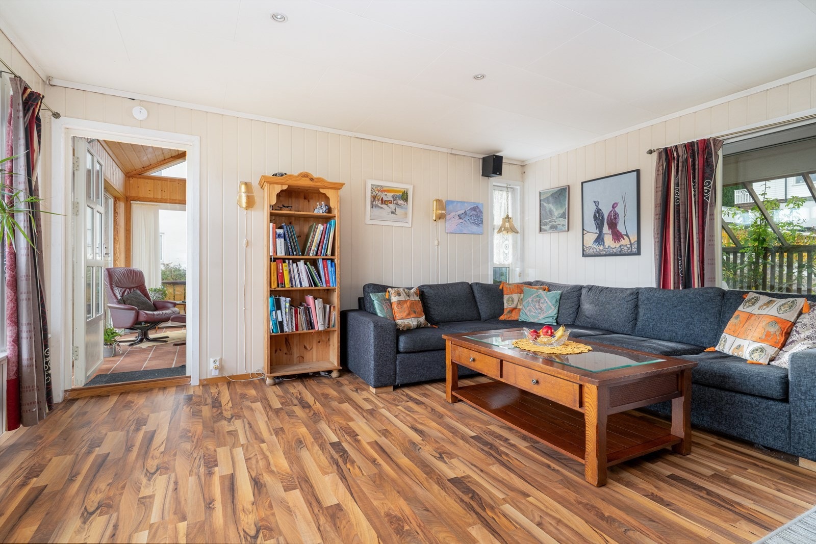 Fin og romslig stue med lyse overflater og delvis åpen løsning til kjøkken med spiseplass. Enkel verandadør til tilliggende vinterhage. Galleribilde