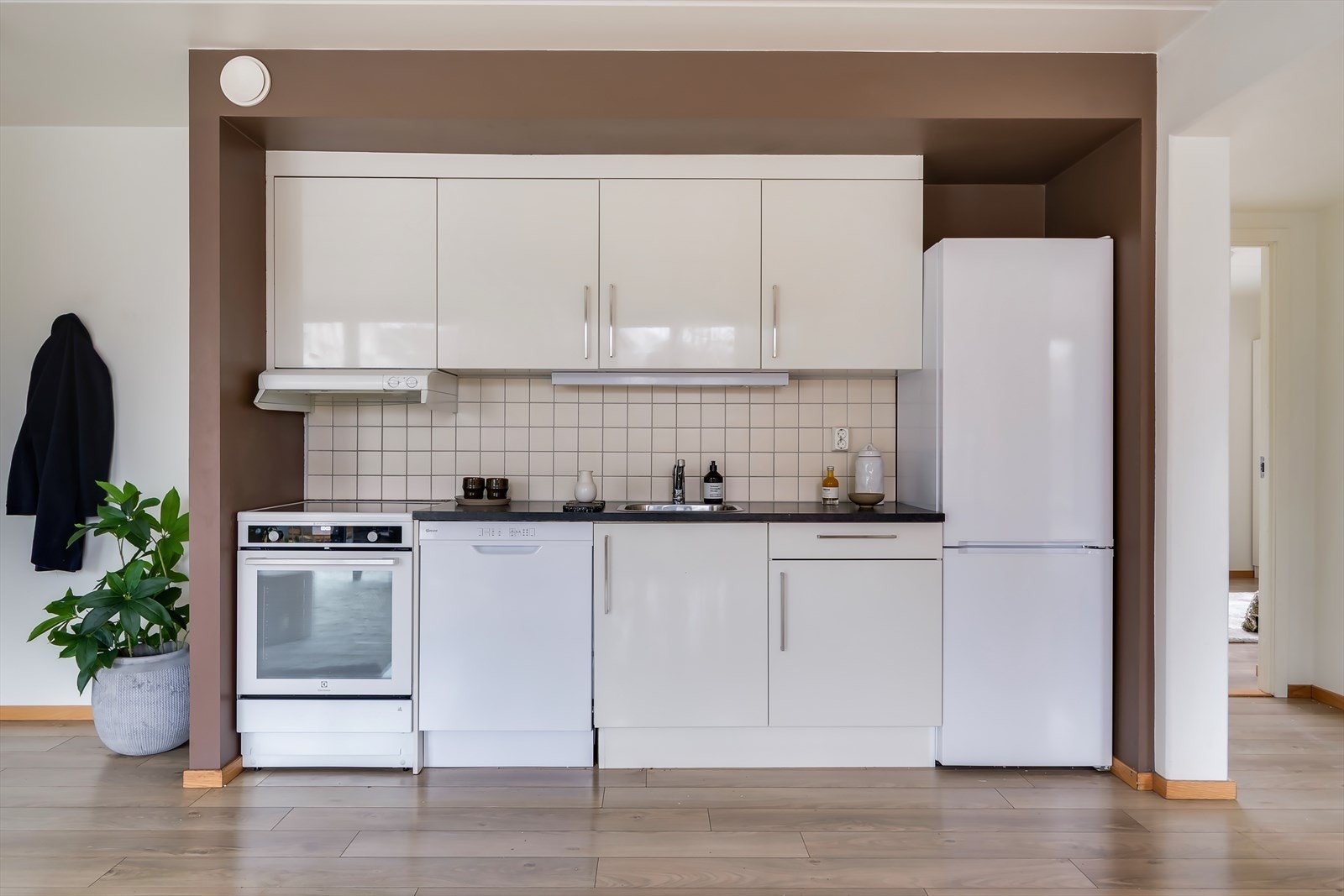 Stilrent kjøkken i delikate fargetoner med praktisk utforming og rikelig med oppbevaringsplass. Det er lagt til rette for frittstående hvitevarer og opplegg for oppvaskmaskin. Hvitevarene medfølger ikke. Galleribilde