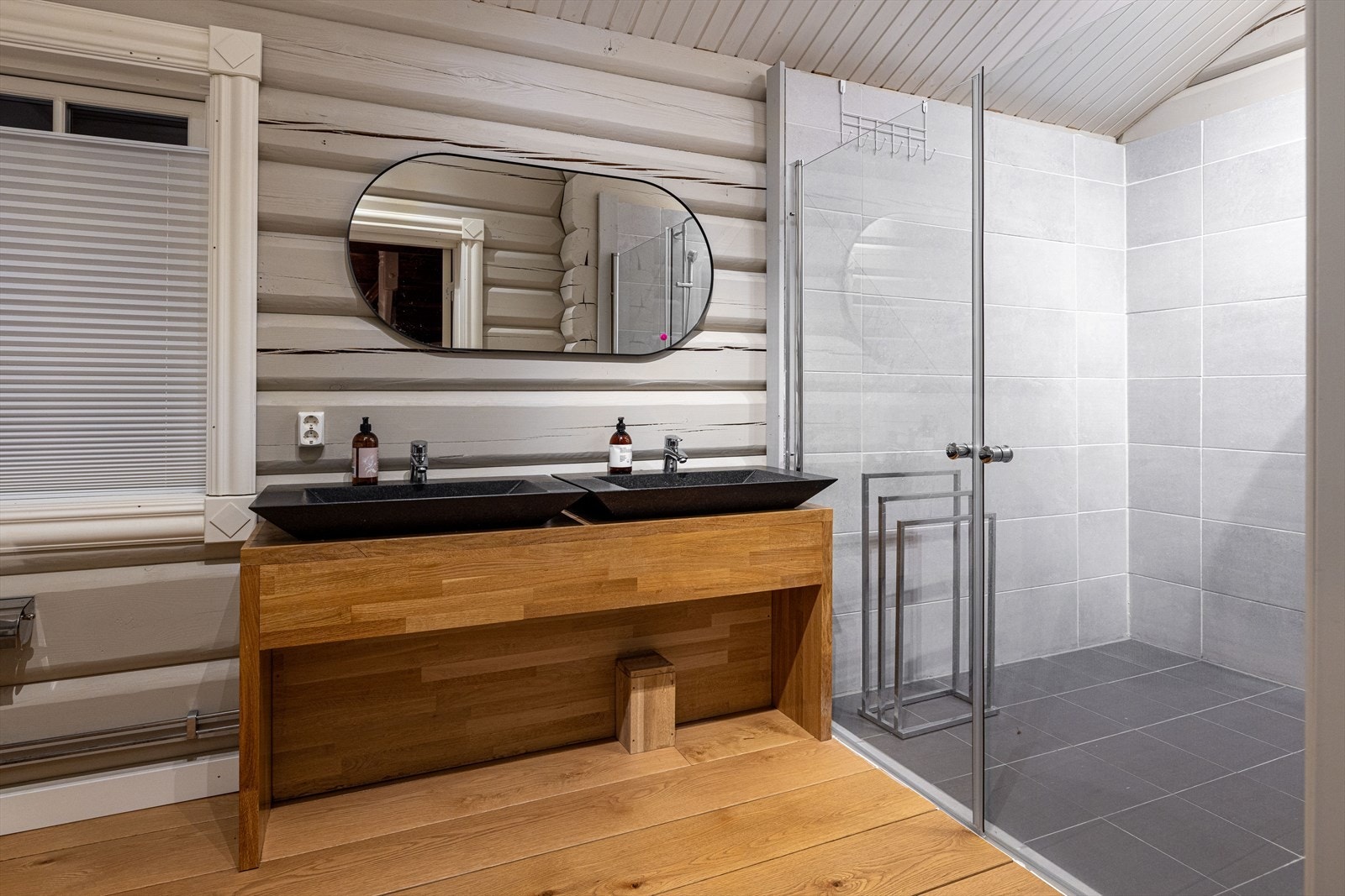 Hovedbaderom utstyrt med toalett, dobbeltservant, og romslig dobbeldusj med innfellbare glassdører Galleribilde