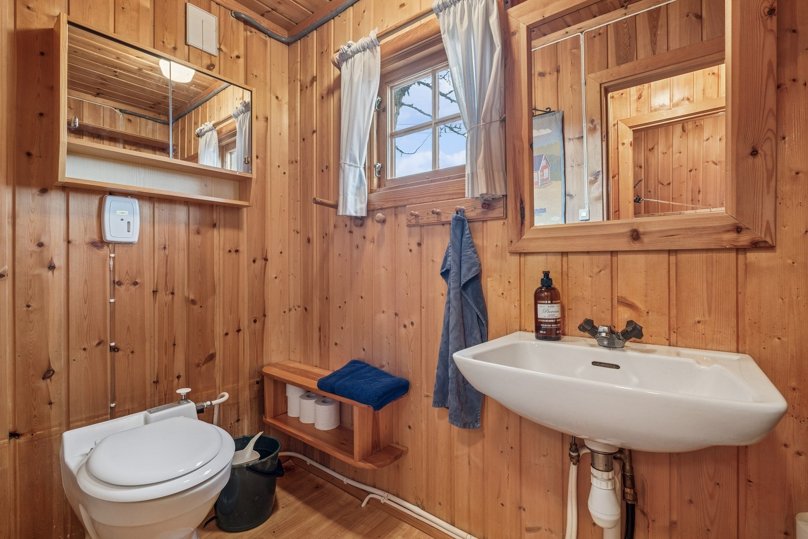 Toalettrommet er utstyrt med gulvmontert toalett, servant og speil. Galleribilde