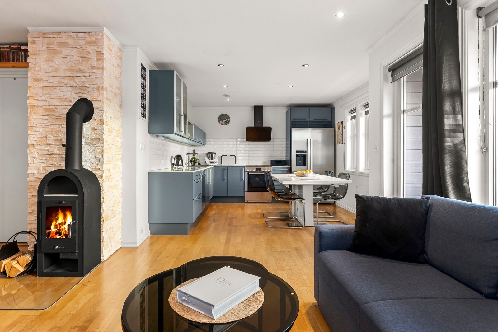 Familiens dagligliv er organisert i allrommet med en sjarmerende peisovn plassert sentralt i rommet. Galleribilde