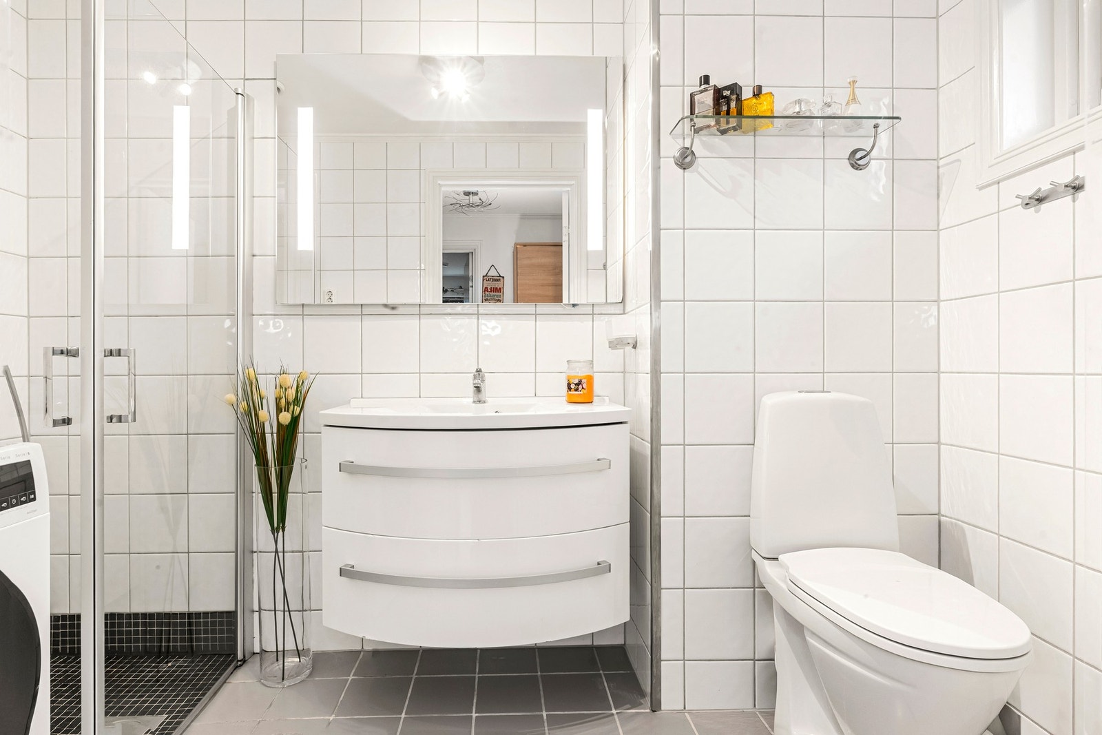 Badet er med elektriske varmekabler i gulv og har innredning med nedfelt servant, gulvfestet toalett, dusjhjørne og opplegg for vaskemaskin. Galleribilde