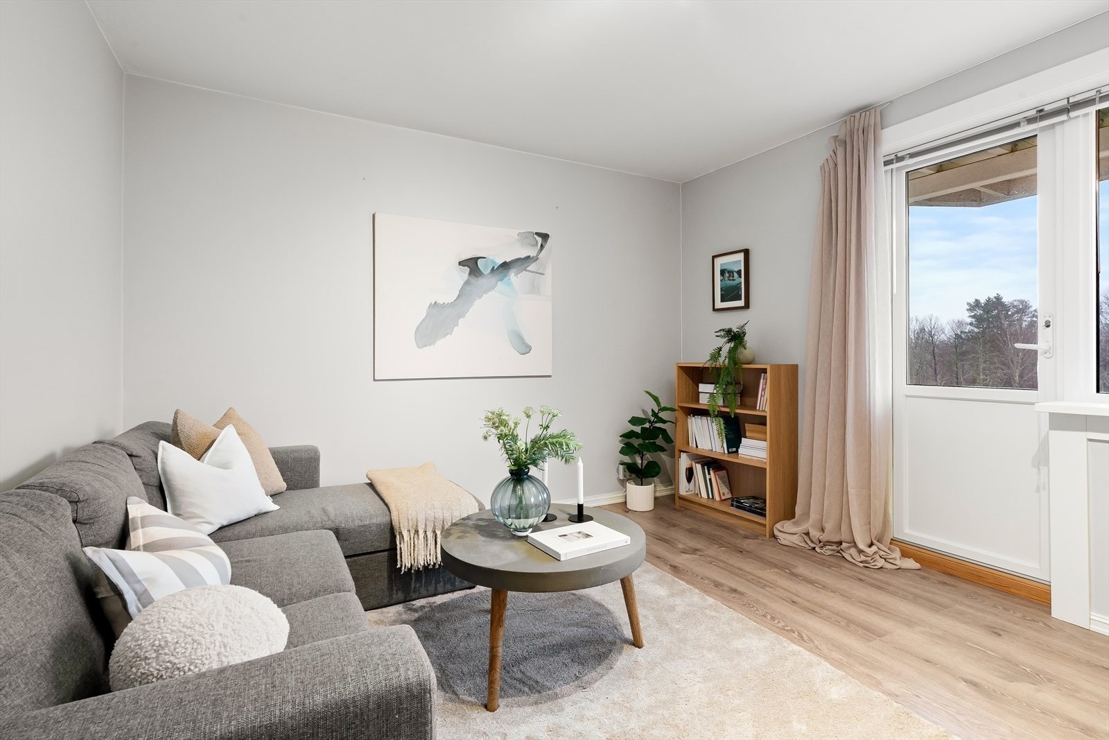 Hyggelig stue med lyse overflater og utgang til balkong. Galleribilde