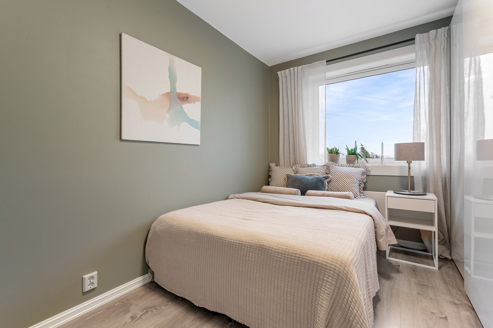 Pent og luftig soverom med duse farger og rikelig med oppbevaringsplass. Galleribilde