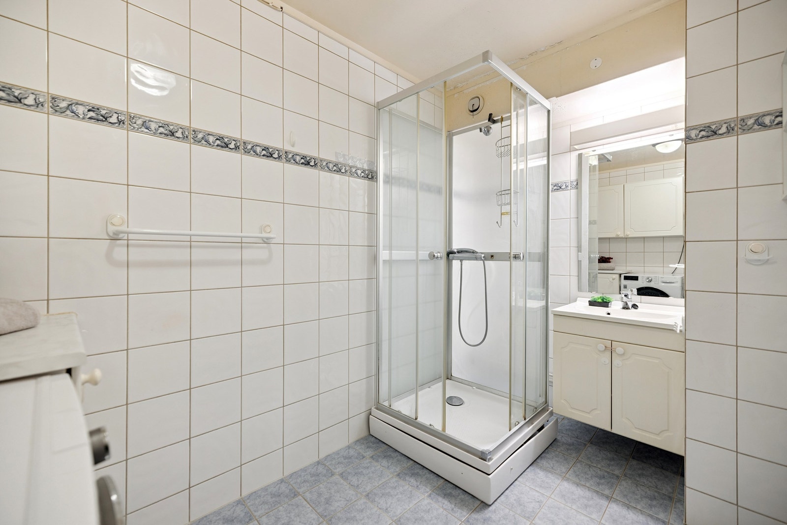 Badet er innredet med servant med underskap, speil og belysning. Galleribilde