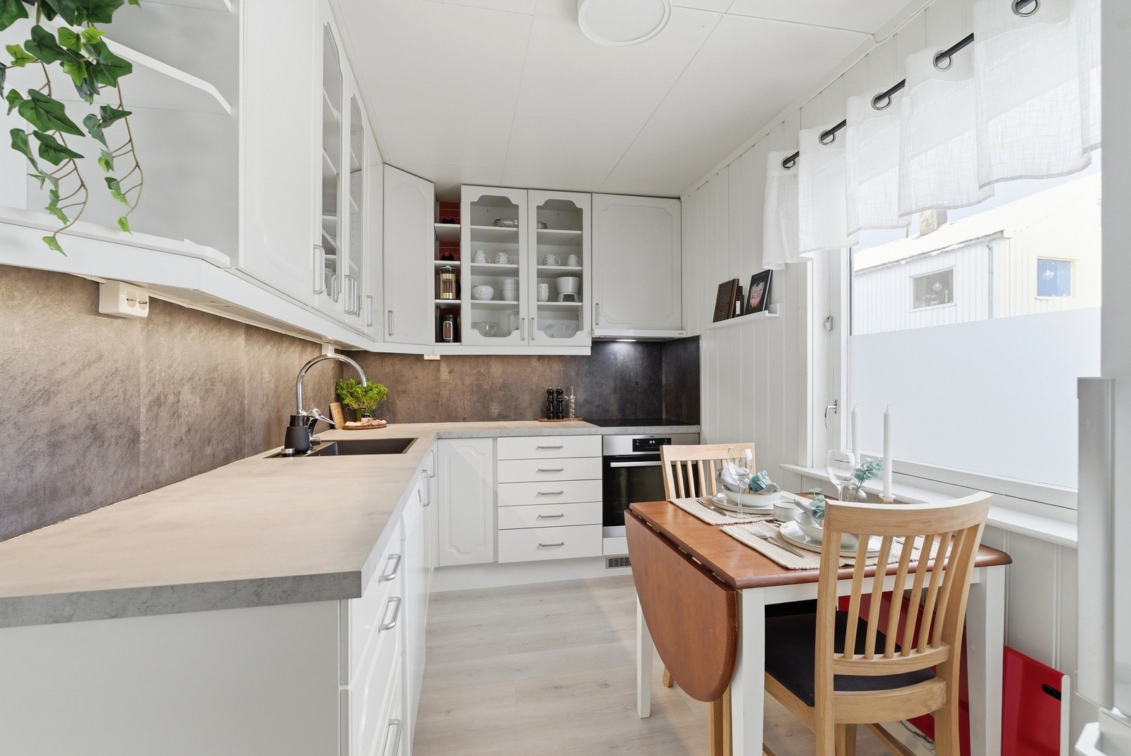 Kjøkken med praktiske løsninger og rikelig med skap- og benkeplass. Galleribilde