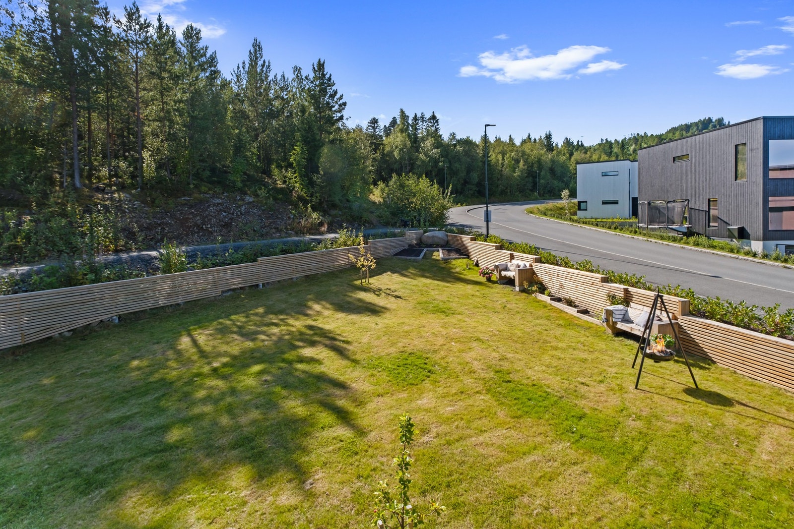 Tomten grenser mot skog og lekeplass. Galleribilde