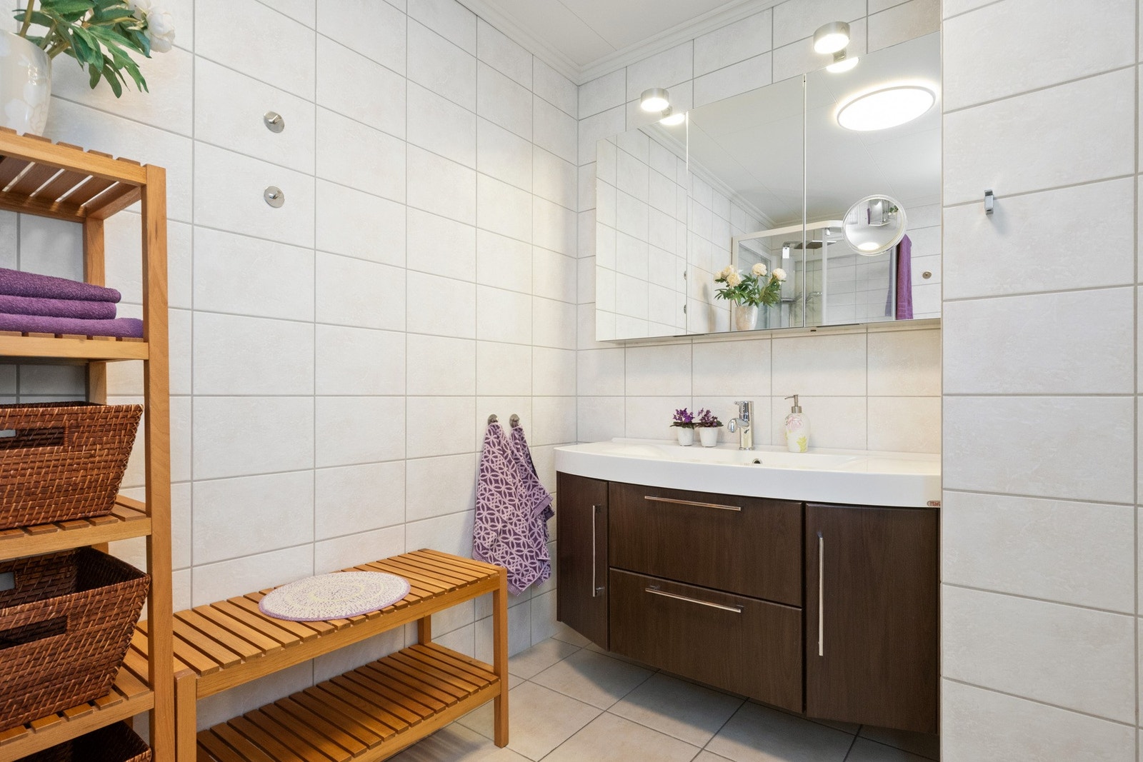 Stor servantinnredning og speilskap gir rikelig plass til lagring Galleribilde